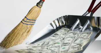 Clean Up Your Finances And Be Debt Free Before 30 With These Rules Sweeping US currency into dust pan --- Image by © Steve Hix/Somos Images/Corbis