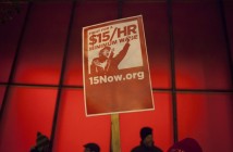 A protest sign is pictured during a rally to raise the hourly minimum wage to $15 for fast-food workers at City Hall in Seattle