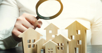 A,Woman,Is,Holding,A,Magnifying,Glass,Over,A,Wooden