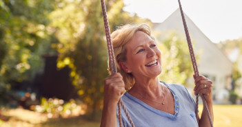 Carefree,Smiling,Retired,Woman,Having,Fun,On,Garden,Swing