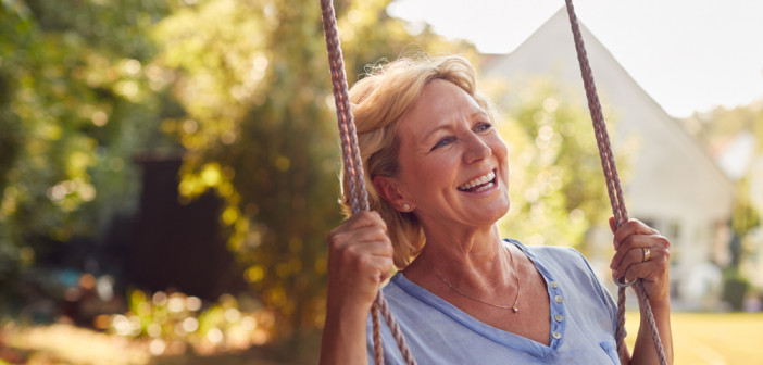 Carefree,Smiling,Retired,Woman,Having,Fun,On,Garden,Swing