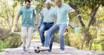 Two,Senior,Man,With,Son,Having,Fun,While,Playing,Football