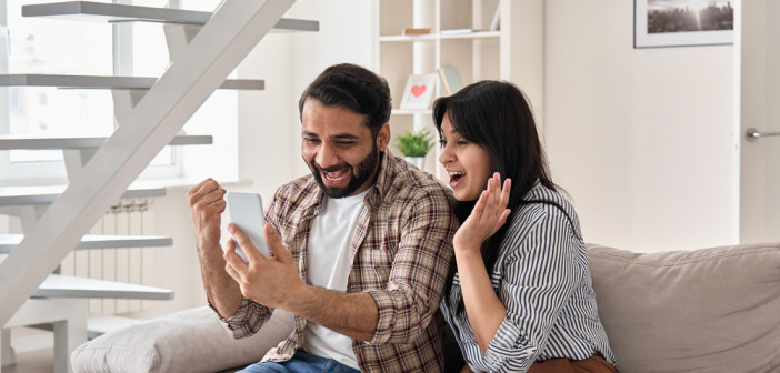 Excited,Happy,Young,Indian,Family,Couple,Winners,Look,At,Smart