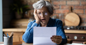 Unhappy,Mature,Wearing,Glasses,Reading,Bad,News,In,Letter,,Stressed