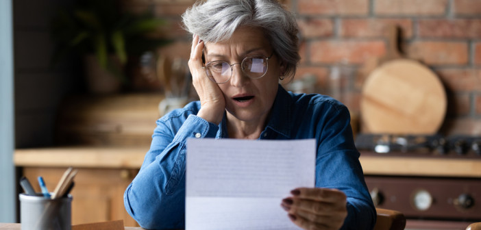 Unhappy,Mature,Wearing,Glasses,Reading,Bad,News,In,Letter,,Stressed