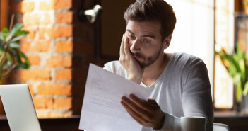 Confused,Frustrated,Young,Man,Reading,Letter,In,Cafe,,Debt,Notification,