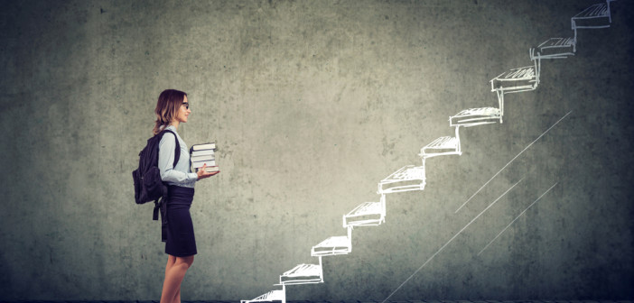 Female,Student,With,Books,Standing,On,The,Stairs,Of,Education