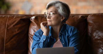 Dreamy,Elderly,Caucasian,Grey-haired,Woman,In,Glasses,Distracted,From,Computer