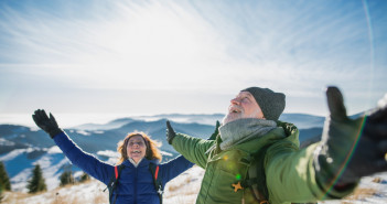 Senior,Couple,Hikers,In,Snow-covered,Winter,Nature,,Stretching,Arms.