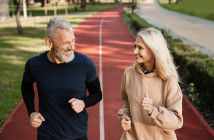 Senior,Mature,Couple,Running,Together,In,The,Park,Stadium,Looking