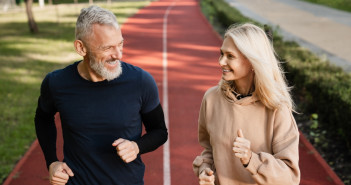 Senior,Mature,Couple,Running,Together,In,The,Park,Stadium,Looking