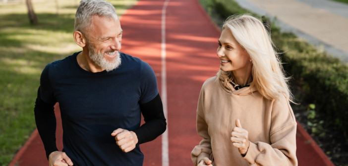 Senior,Mature,Couple,Running,Together,In,The,Park,Stadium,Looking