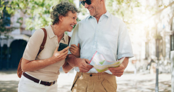 Retired,Couple,Walking,Around,The,Town,With,A,Map.,Smiling