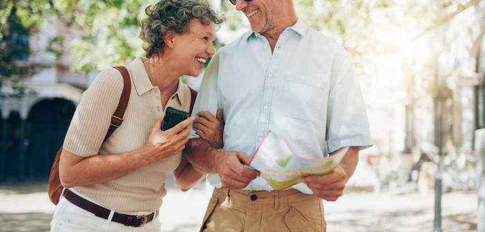 Retired,Couple,Walking,Around,The,Town,With,A,Map.,Smiling