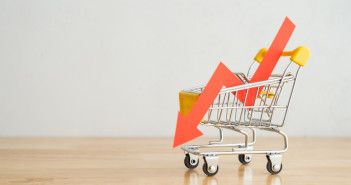 Shopping,Trolley,With,Red,Chart,Falling,Down,On,Wooden,Table