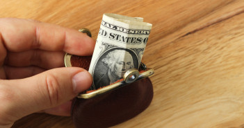 Personal finance tips: How to get out of debt and STAY out A,Hand,Holding,A,Tiny,Purse,Which,Has,A,Dollar