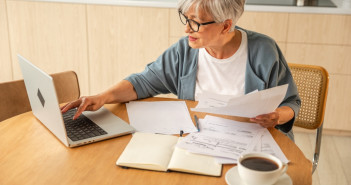 Middle,Aged,Senior,Woman,Sit,With,Laptop,And,Paper,Document,