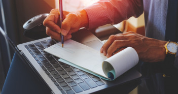 Businessman,Hand,Writing,And,Signing,White,Empty,Bank,Checkbook,With