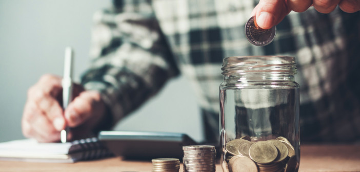 Business,Man,Putting,Coin,In,Glass,Bottle,Saving,Bank,And