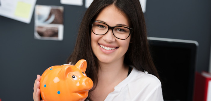 Successful,Young,Businesswoman,Or,Entrepreneur,Holding,A,Piggy,Bank,Looking