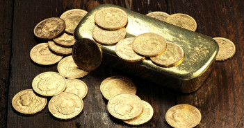 Swiss,Vreneli,Gold,Coins,And,A,Gold,Ingot,On,Wooden