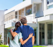 Couple,Embracing,In,Front,Of,New,Big,Modern,House,,Outdoor