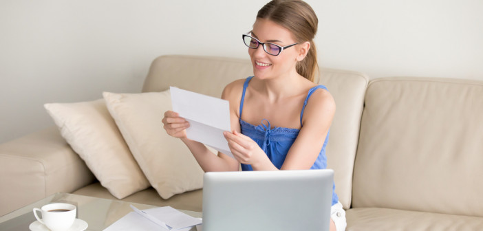 Happy,Woman,Reading,Letter,With,Good,News,Sitting,On,Sofa