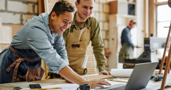 Warm,Toned,Portrait,Of,Animated,Carpenters,Using,Laptop,And,Discussing