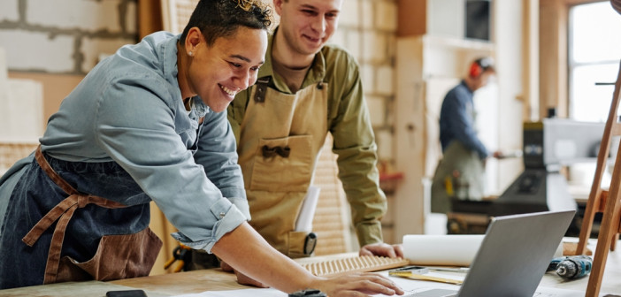 Warm,Toned,Portrait,Of,Animated,Carpenters,Using,Laptop,And,Discussing