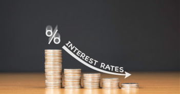 Will the UK and US cut interest rates like Europe? Stacked,Us,Quarter,Coins,On,Wooden,Table,With,White,Illustration