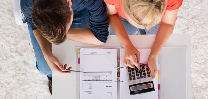 Couple,Using,Calculator,For,Calculating,Invoice,,Tax,,Bills,And,Retirement