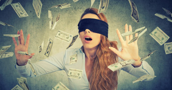 Blindfolded,Young,Entrepreneur,Businesswoman,Trying,To,Catch,Dollar,Bills,Banknotes