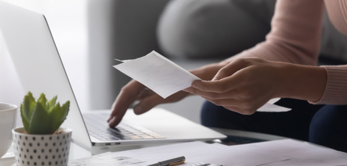 Close,Up,Woman,Holding,Receipt,,Using,Laptop,,Calculating,Bills,,Money,