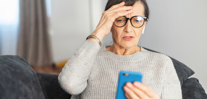 Worried,Senior,Woman,Staring,At,A,Smartphone,Screen,At,Home,