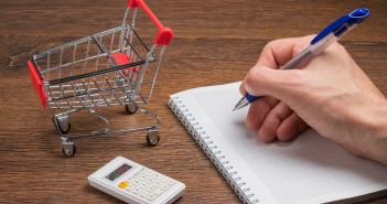 Man,Calculates,The,Budget.,Shopping,Cart,A,On,Table,With