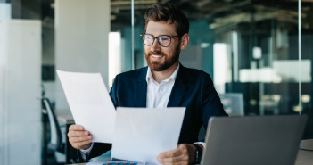 Happy,Businessman,Reading,Papers,And,Business,Reports,,Rejoicing,In,The