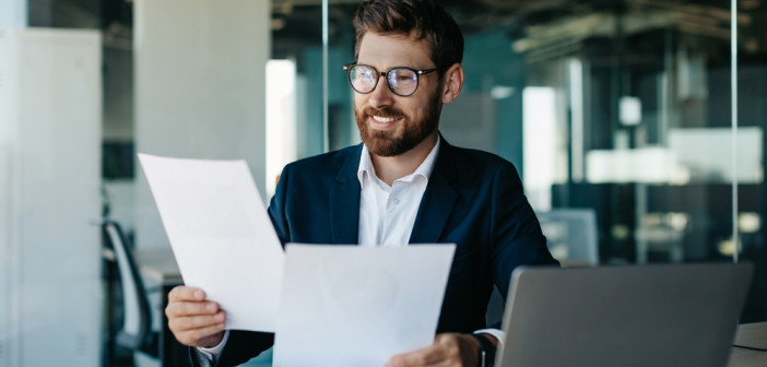 Happy,Businessman,Reading,Papers,And,Business,Reports,,Rejoicing,In,The